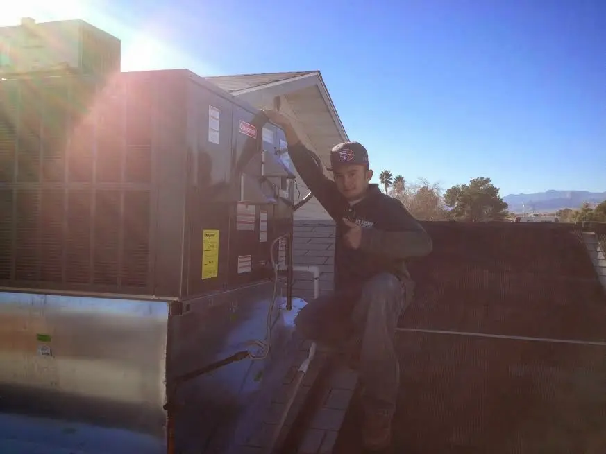 HVAC technician performing Boiler Repair on a rooftop unit in Lindenwold